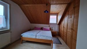 a small bedroom with a bed with purple pillows at FeWo 1 Rolf Koglin in Gunzenhausen