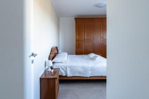 1 dormitorio con 1 cama y armario de madera en Da nonno al Mare - YourPlace Abruzzo, en Fossacesia