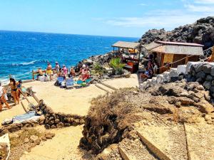 a group of people sitting on a beach near the ocean at Apartamento vacacional Paradise in Arona