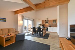 a living room and kitchen with a table and chairs at Landhaus am See Appartement LH 05 in Schwangau