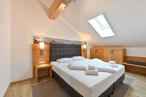 a bedroom with a large white bed with a skylight at Landhaus am See Appartement LH 05 in Schwangau