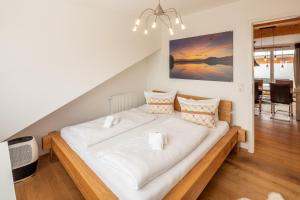 a large bed with white sheets and pillows in a room at Chalet am Breitenberg Appartement CB 08 in Pfronten