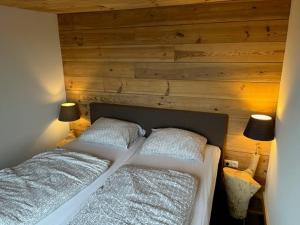 een slaapkamer met een bed met 2 kussens en 2 lampen bij De Hazeldonck in Gemert