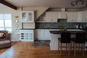 a kitchen with white cabinets and black counter tops at Lehinch Lodge in Lahinch