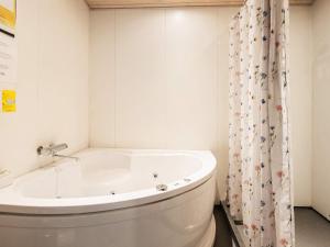 a white tub in a bathroom with a shower curtain at 8 person holiday home in Vestervig in Vestervig