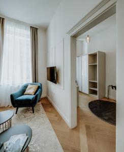 salon z niebieskim krzesłem i telewizorem w obiekcie LAVilla Osijek w mieście Osijek