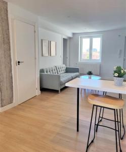 uma sala de estar com um sofá e uma mesa em Vistas, recién reformado, 2 dormitorios dobles. em Santander