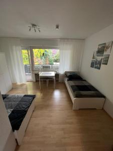 1 Schlafzimmer mit 2 Betten, einem Tisch und einem Fenster in der Unterkunft Zentral gelegene Apartments am Schillerplatz in Mönchengladbach