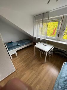 ein kleines Zimmer mit einem Tisch und einem Bett in der Unterkunft Zentral gelegene Apartments am Schillerplatz in Mönchengladbach