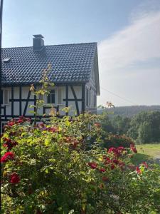 une maison avec un bouquet de fleurs devant elle dans l'établissement Ferienwohnung am alten Backhaus, à Bad Berleburg