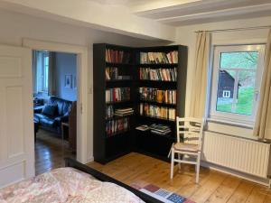 una sala de estar con una estantería llena de libros en Ferienwohnung am alten Backhaus, en Bad Berleburg