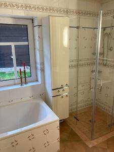 baño con bañera y ducha y ventana en Ferienwohnung am alten Backhaus, en Bad Berleburg