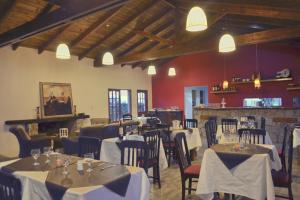 un restaurante con mesas y sillas con mantel blanco en Senderos del Tao en Las Rabonas