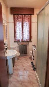 ein Bad mit einem Waschbecken, einem WC und einem Fenster in der Unterkunft Guest House Romero in Cadelbosco di Sotto