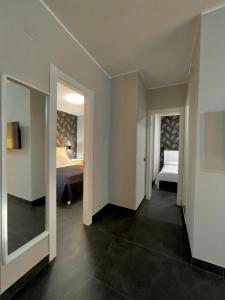 Zimmer mit einem Schlafzimmer mit einem Bett und einem Spiegel in der Unterkunft ALDIVA ROOMS in Torvaianica