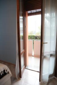 eine offene Tür zu einem Zimmer mit Fenster in der Unterkunft Guest House Romero in Cadelbosco di Sotto