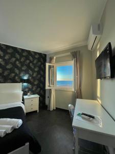 a hotel room with a bed and a window at ALDIVA ROOMS in Torvaianica