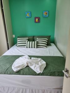 uma cama com uma camisa e uma gravata borboleta em Beach Class Resort Muro Alto BMS em Porto de Galinhas