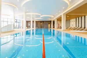 duży kryty basen z niebieską wodą w budynku w obiekcie Aqua Polanki Apartament B014 Eltom Tour w Kołobrzegu