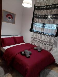a bedroom with a red bed with two pairs of socks at Σπίτι με θέα 