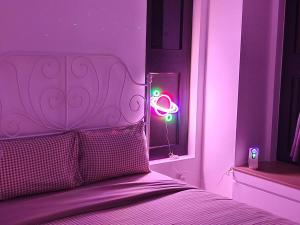 a bedroom with a bed with a neon sign in a window at Sunway Grid@Cyberpunk/Sunway Bigbox/Golf Driving in Kampong Pendas