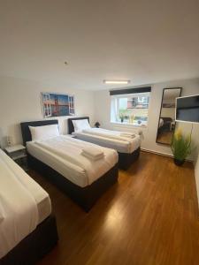 a hotel room with two beds and a television at City Apartments direkt am Hauptbahnhof - Perfekt für Pendler und Monteure in Neumünster