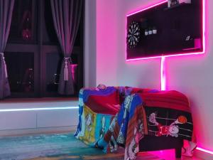 a room with a couch with a pink light at Sunway Grid@Cyberpunk/Sunway Bigbox/Golf Driving in Kampong Pendas