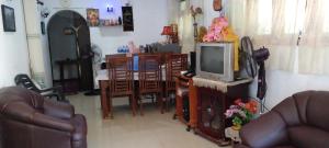 un soggiorno con TV, tavolo e sedie di Ajith Rest a Weligama