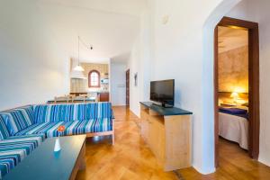 a living room with a blue couch and a television at Comitas Tramontana Park in Fornells