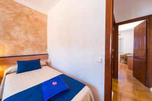 a bedroom with a bed with a blue pillow on it at Comitas Tramontana Park in Fornells