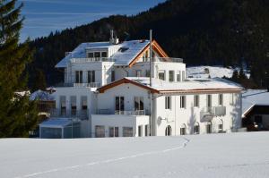 a large white building in the snow with snow covered ground at Chalet am Breitenberg Appartement CB 11 in Pfronten