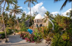 un complejo con piscina y palmeras en Xanadu Villas & Retreat, en Bwejuu