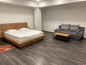 a bedroom with a bed and a couch at One Day Hotel in Yerevan