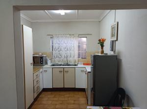 a small kitchen with a refrigerator and a window at 18 on Shores in Pietermaritzburg