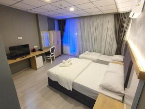 um quarto de hospital com duas camas e uma televisão em ÖZTÜRKS HOTEL em Istambul