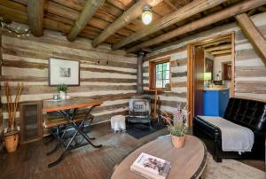 a living room with wooden walls and a table at A rustic cabin in the woods in Orangeville