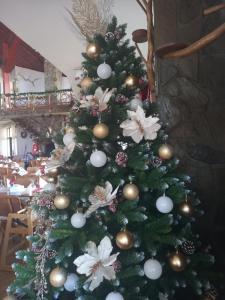 uma árvore de Natal com ornamentos em Hotel Rozmarin em Predeal