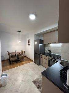 a kitchen with a table and a dining room at Vert Apartment in Banja Luka
