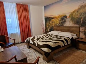 a bedroom with a zebra print bed and a table at Motel “La Butuci” in Timisul de Jos