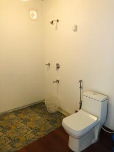 a bathroom with a white toilet in a room at Agonda Beach Chalets in Agonda
