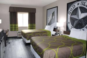 una camera d'albergo con due letti e una televisione di Super 8 by Wyndham Lubbock West a Lubbock