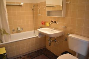 een badkamer met een wastafel, een toilet en een bad bij Astoria (213 Le) in Lenzerheide