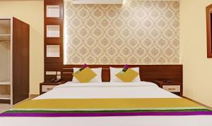 a bedroom with a large white bed with yellow pillows at Itsy By Treebo - Sapphire Residency in Manjeri