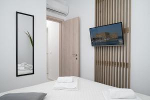 a bedroom with a bed with a tv on the wall at Amersa Luxury Apartments in Heraklio Town