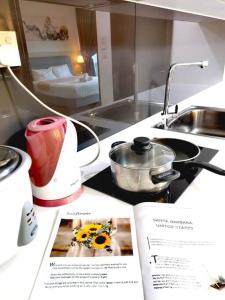 a kitchen counter with a magazine and a kitchen sink at Almas Suites Cozy Muji Netflix 100mbps By STAY in Nusajaya