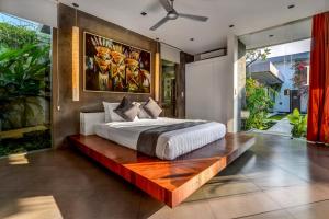 a bedroom with a large bed on a wooden platform at Villa Banyu in Seminyak
