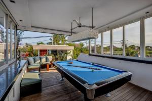 a pool table in a room with windows at Villa Banyu in Seminyak