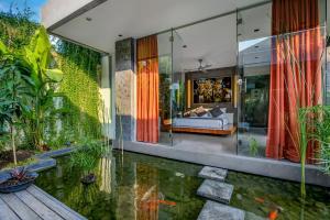 a house with a pond in the middle of it at Villa Banyu in Seminyak