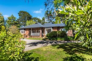 a brick house with a driveway in front of it at Kerrisdale Bowral in Bowral