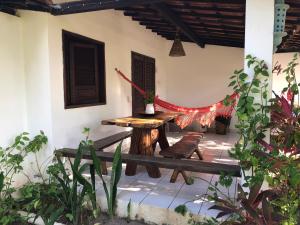 a patio with a table and a hammock at Pousada das Oliveiras in Porto De Galinhas